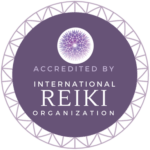 Accredited badge from the International Reiki Organization, featuring a decorative circular design and a central emblem, signifying certification in Reiki practices.